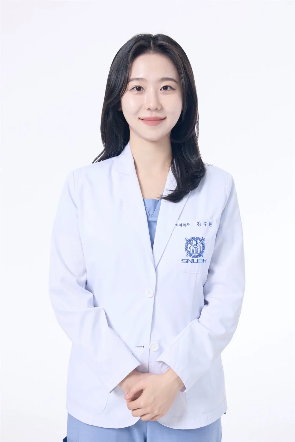 이름표와 서울대학교치과병원 로고가 있는 흰 가운을 입고 손을 모은 채 미소 짓는 김수완 대표원장의 프로필 사진입니다.